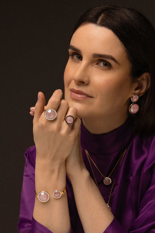 O Anel Único - Quartzo Rosa faz parte da Coleção Singular, que celebra a beleza e a nobreza de uma mulher. Este anel é a expressão do simples em sua forma mais magnífica, apresentando o Quartzo Rosa, a pedra do amor incondicional. Banhado a Ouro 18K, ele promove paz interior, afeto e a manifestação do amor em todas as suas formas, sendo uma peça marcante que aflora a imponência feminina em sua essência.