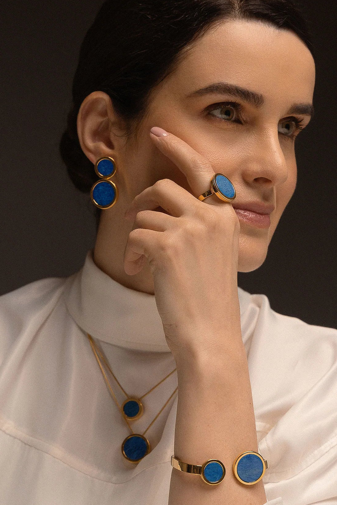 O Anel Único - Feldspato Azul Anil faz parte da Coleção Singular, que destaca a exclusividade e o valor individual de cada mulher. O Feldspato Azul Anil é uma pedra que favorece a intuição, a autoconfiança e a clareza mental. Com um design imponente e banhado a Ouro 18K, esta joia transforma a simplicidade em uma peça magnífica, perfeita para quem deseja expressar sua força com elegância e serenidade.